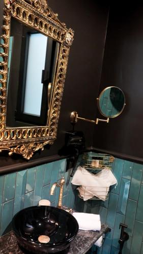 a bathroom with a black sink and a mirror at Lord Byron Luxury Suites in Missolonghi