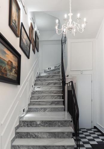 a hallway with a staircase with a chandelier at Lord Byron Luxury Suites in Missolonghi