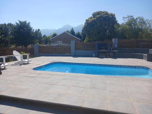 a swimming pool in a backyard with a fence at Gables B&B Guesthouse in George