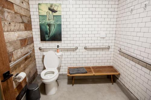 a bathroom with a toilet and a wooden bench at PodShare East Hollywood in Los Angeles