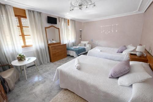 a hotel room with two beds and a table at Casa Rural Nito - Naturaleza y Descanso en Asturias in Villayón
