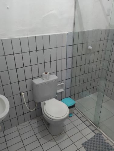a white bathroom with a toilet and a sink at Residencial Portuguesa in Natal