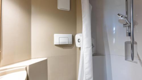 a white bathroom with a shower and a sink at Premiere Classe Limoges Nord in Limoges