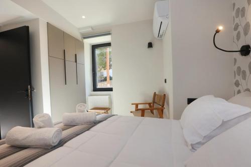 a bedroom with a large white bed with towels on it at VF34 Patio House in Ermoupoli