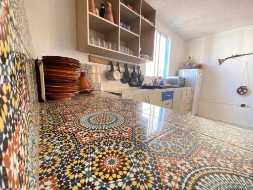 a kitchen with a mosaic tile floor on a counter at Red Carpet Surf Camp Tamraght , Sea & Mountain View, Surf Lessons Available in Tamraght Ouzdar