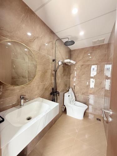 a bathroom with a white sink and a toilet at Phương Ngân HOTEL in Hà Tiên