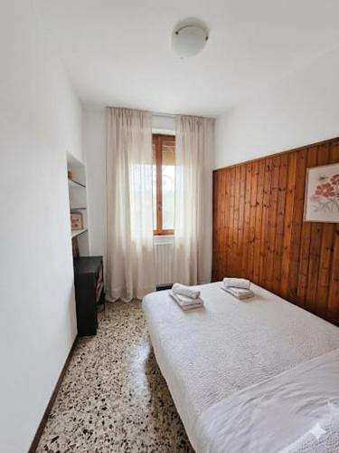 a bedroom with a large bed with a wooden headboard at Casa da Ste AC Free Parking in Mandello del Lario