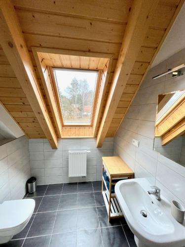 a bathroom with a white sink and a window at Apartman Riviera 41 in Lipno nad Vltavou