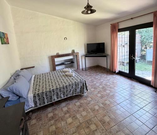 a bedroom with a bed and a television in it at Paz en las sierras in José de la Quintana