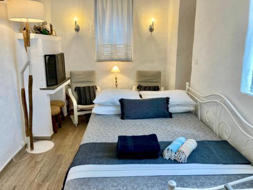 a hotel room with two beds and a television at Traditional Villa Sofia in Koskinou