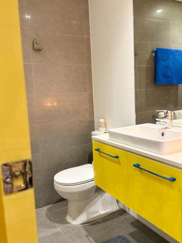 a bathroom with a white toilet and a sink at Banana Bliss - Spacious 2 Bedroom CBD Apartment with 2 Balconies, 2 Bathrooms & Parking Option in Melbourne
