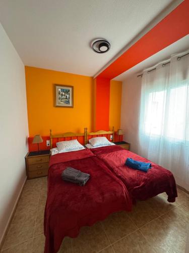 a bedroom with a large bed with red and yellow walls at Apartment Vicente casa 119 in Torrevieja