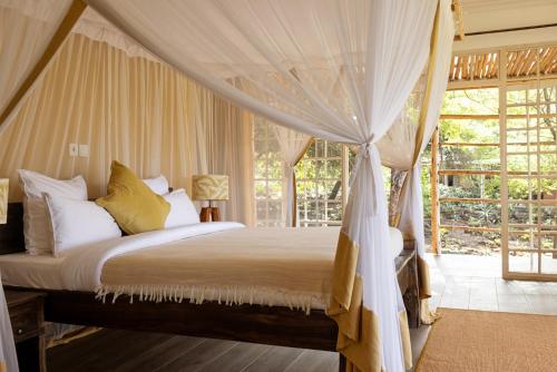 a bedroom with a bed with a canopy at Olerai Lodge in Arusha