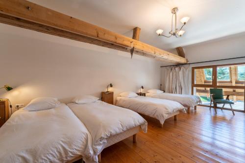 three beds in a room with wooden floors at Entre Loue et Lison in Amondans
