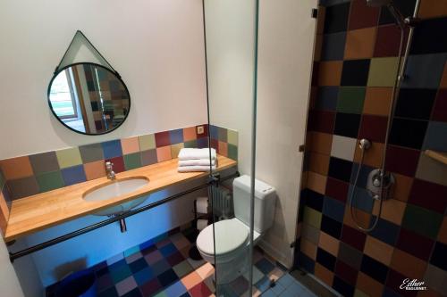 a bathroom with a toilet and a sink and a mirror at Entre Loue et Lison in Amondans