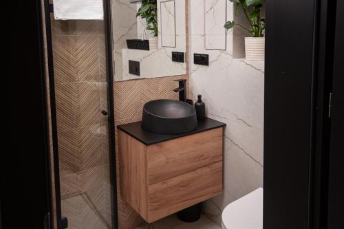 a bathroom with a wooden vanity with a sink at Apartament Podchorążych Dęblin in Dęblin