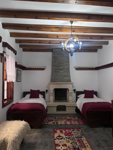 a bedroom with two beds and a fireplace at Hotel Berati in Berat