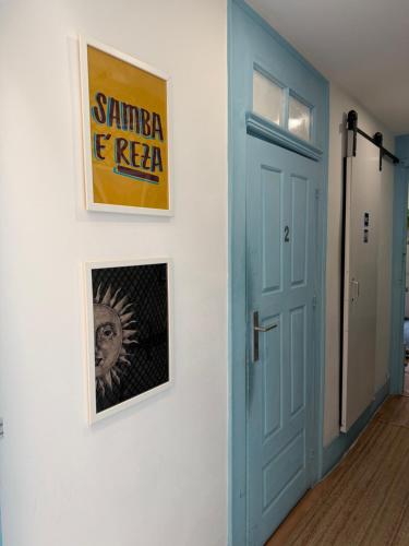a hallway with a blue door and posters on a wall at Guest World in Porto