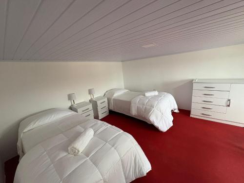 a bedroom with two beds and a red floor at Apartamentos Plaza Minas in Minas