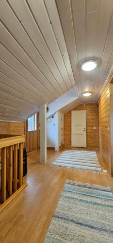 a large room with a wooden ceiling and a rug at Arctic House Kemi 7 GUEST, outdoor tentsauna Experience in Kemi