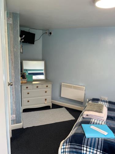 a bedroom with a bed and a dresser and a mirror at The Creamery in Liskeard