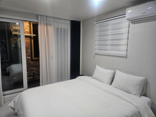 a white bed in a room with a window at 아름다운호텔 in T'ongyŏng