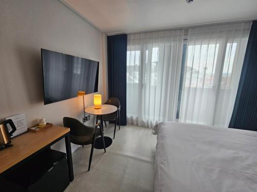 a hotel room with a bed and a table and a television at 아름다운호텔 in T'ongyŏng