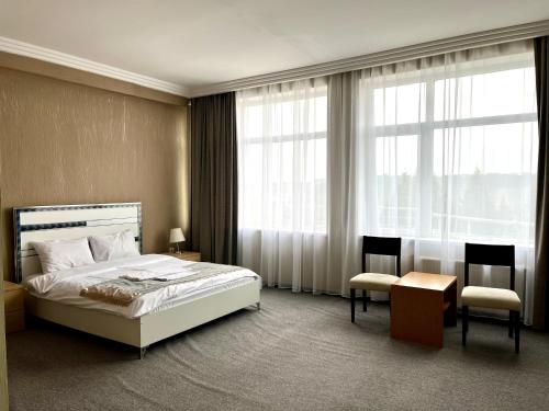 a bedroom with a bed and a table and chairs at Arena Hotel Tovuz in Tovuz