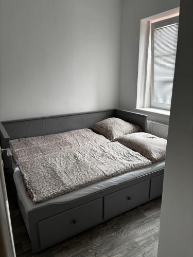 a bed sitting in a room with a window at Apartmán u Hradu 2 in Cheb