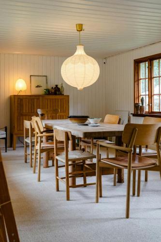 a dining room with a large wooden table and chairs at Thatched Hideaway At Svinkløv Forest Edge in Fjerritslev