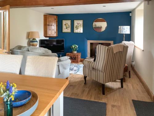 a living room with blue walls and a living room with a couch at The Mains in Keldhead