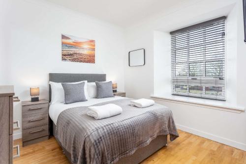 a bedroom with a large bed and a window at No1 Coppergate - Donnini Apartments in Prestwick