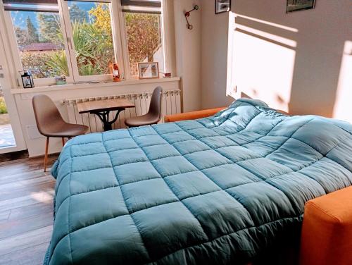 a bedroom with a large blue blanket on a bed at Altea - Lago di Como nuovo accogliente mini appartamento vicino alla spiaggia e giardino in Dervio