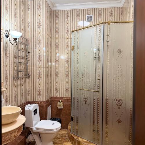 ein Badezimmer mit Toilette und Dusche in der Unterkunft Lion Hotel in Astana