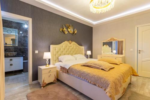 a bedroom with a large bed and a chandelier at Complex Rediu 54-PentHouse in Rediu