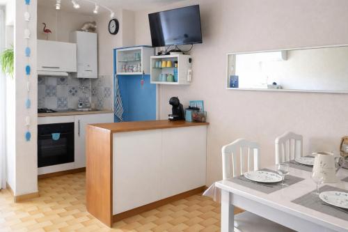 a kitchen with a table and a kitchen with a table and chairs at MES VACANCES A LA MER studio 4 pers, parking privé, wifi, linges fournis, climatisation in La Grande Motte