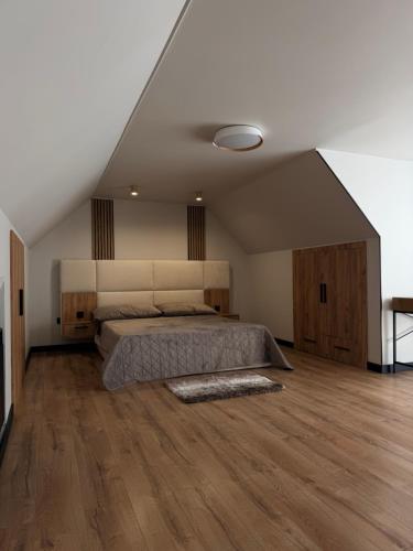 a bedroom with a bed and a wooden floor at Stone & Soul House in Chernihiv