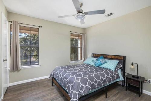 a bedroom with a bed and two windows at Spacious 4BR Home with Pool BBQ & Games in Grand Prairie