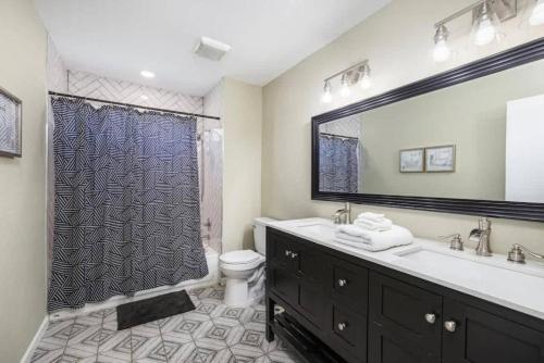 a bathroom with a sink and a toilet and a shower at Spacious 4BR Home with Pool BBQ & Games in Grand Prairie