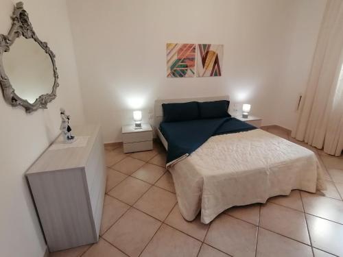 a bedroom with a large bed and a mirror at Luminoso appartamento sul mare! in Piombino