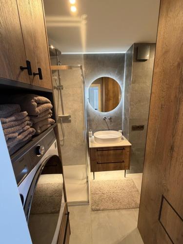 a small bathroom with a sink and a mirror at JAVA ESTATE apartment in Rēzekne