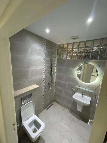 a bathroom with a toilet and a sink and a mirror at Location Appartement luxe in Mahdia