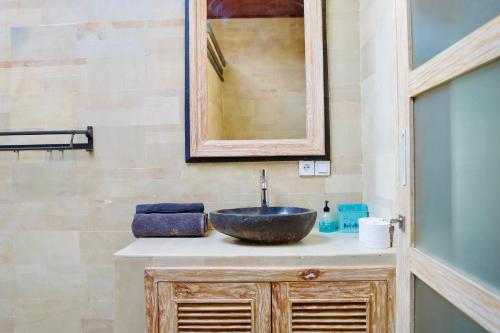 a bathroom with a sink and a mirror at Inaya Private Pool Villa in Ambat