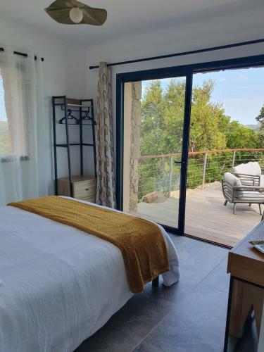 a bedroom with a bed and a sliding glass door at Villa Cocooning, Piscine privative à Figari in Figari
