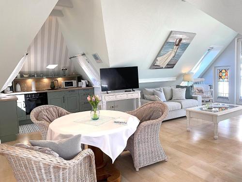 a living room with a table and chairs and a couch at Haus Anholt in Timmendorfer Strand