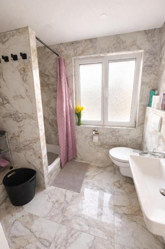 a bathroom with a sink and a toilet and a window at Ferienwohnung AyNa 3, direkt an der Schweizer Grenze in Bad Säckingen