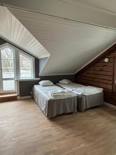 two beds in a attic room with two windows at Marstrand in Marstrand