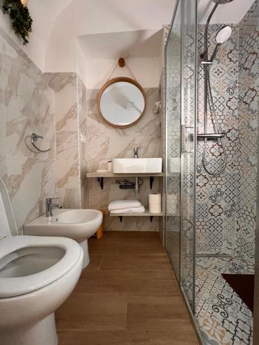 a bathroom with a toilet and a sink and a mirror at Casa Vacanza Pietre & Cielo in Ceglie Messapica
