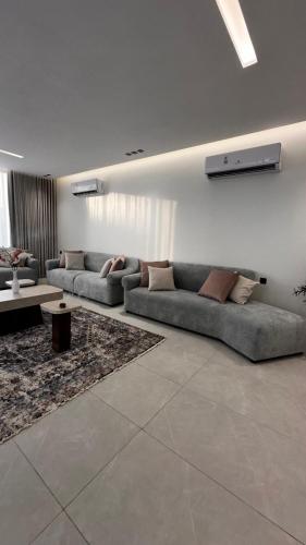 a living room with two couches and a table at شاليه بيرلا in Jeddah
