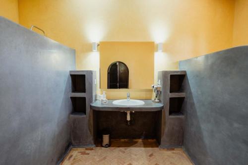 a bathroom with a sink and a mirror at DOMAINE DU DOUAR in Marrakesh